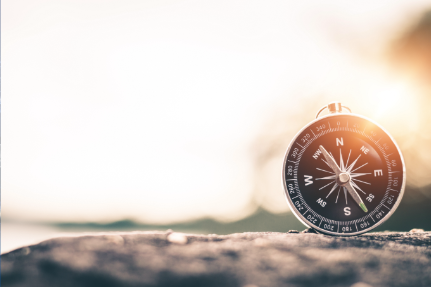 compass in front of a sunrise